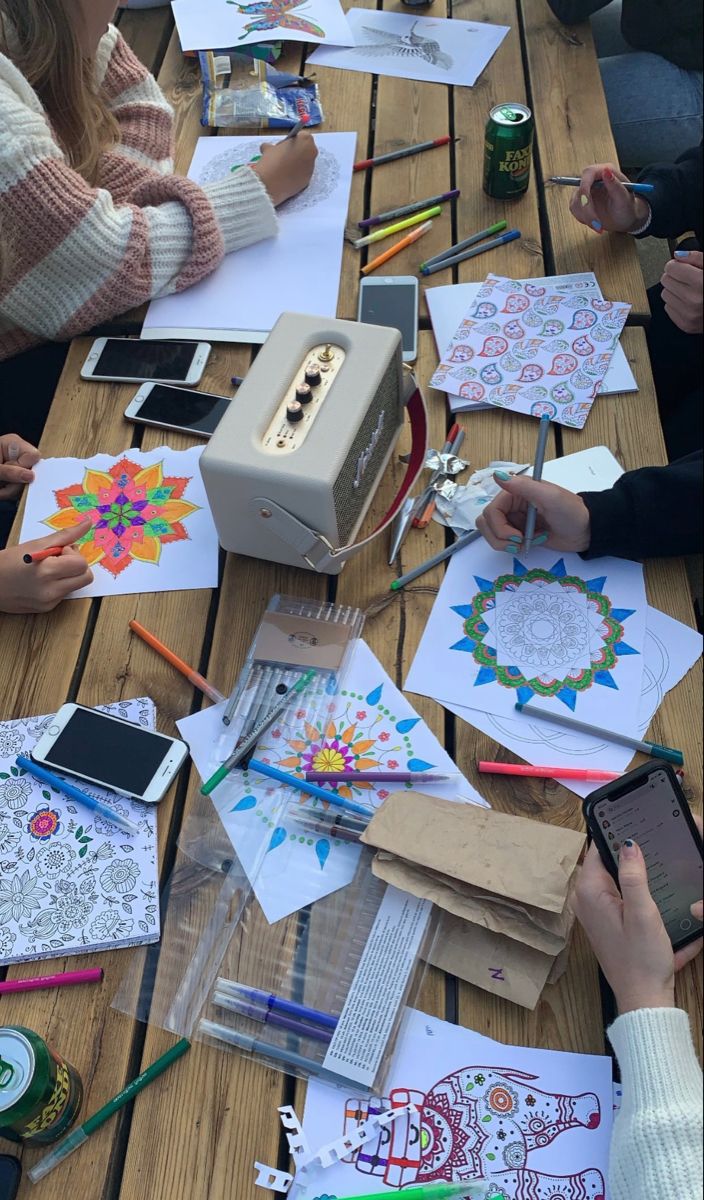 several people sitting at a table with paper and pencils