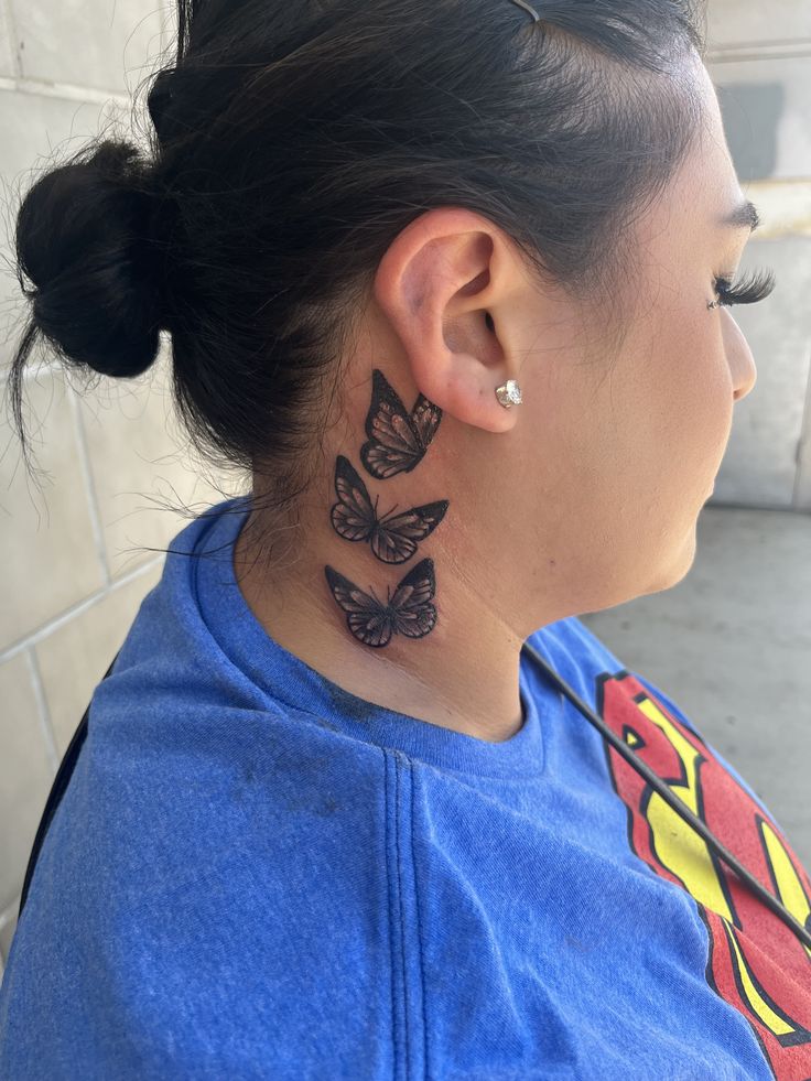 a woman with a butterfly tattoo on her neck