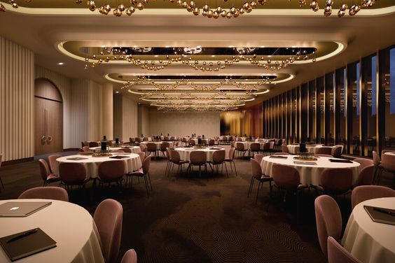 a banquet room with round tables and chandeliers