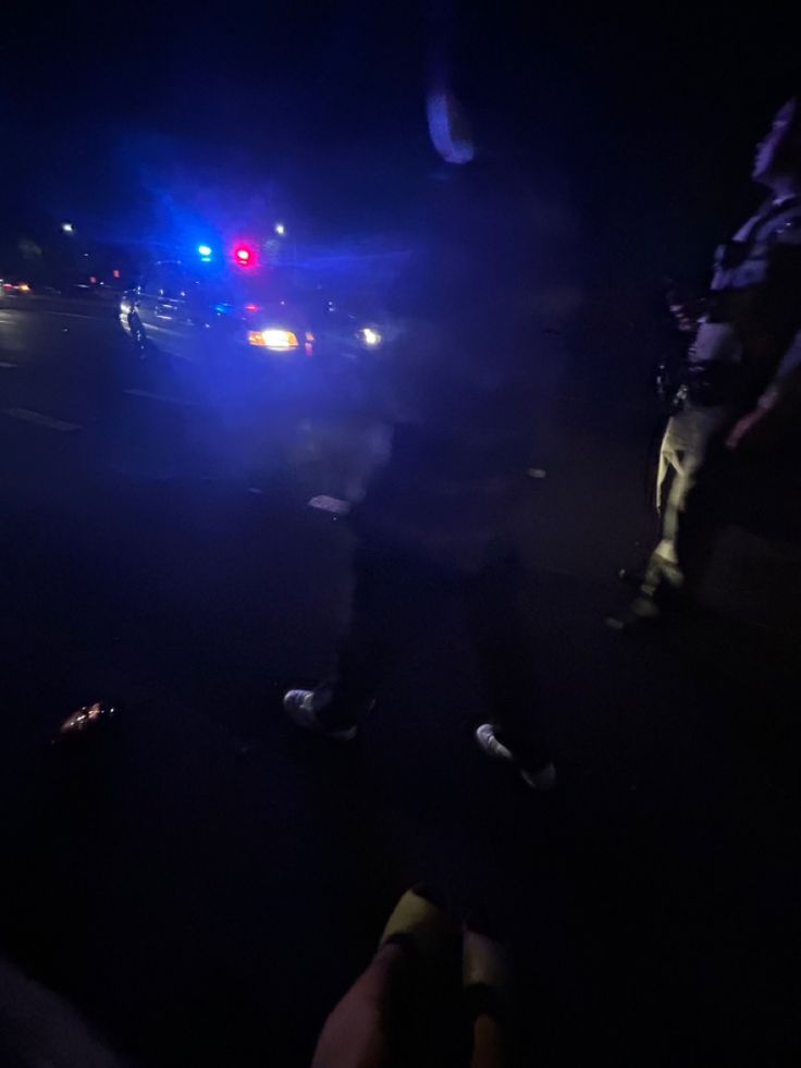 two police officers standing in the street at night