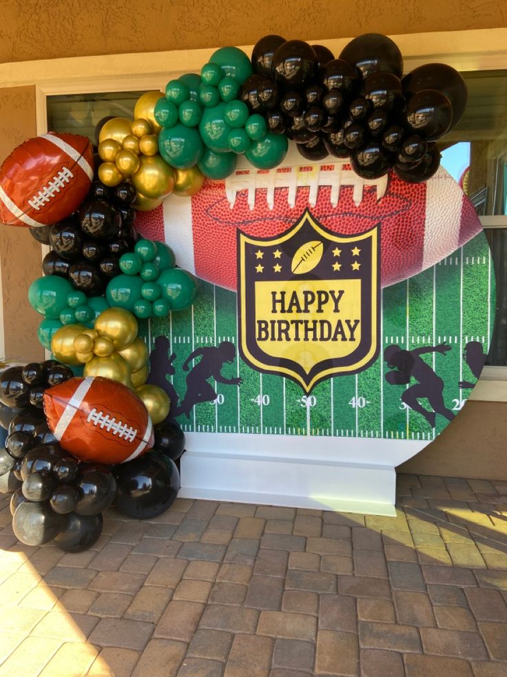 a balloon arch with footballs and balloons on it