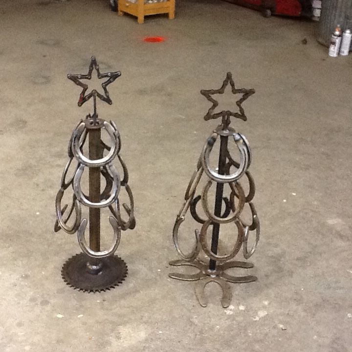 two metal christmas trees sitting on top of a floor