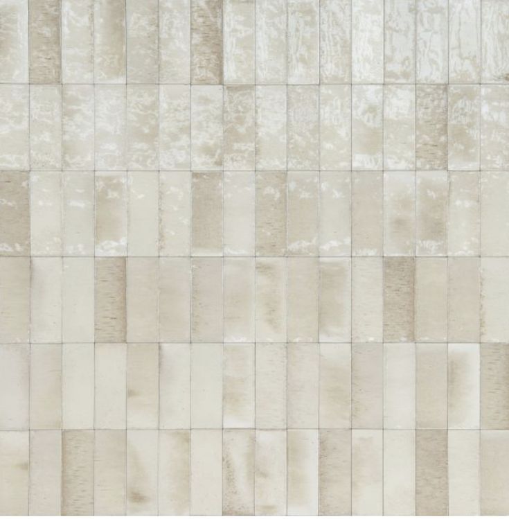 a white and beige tile wall with squares