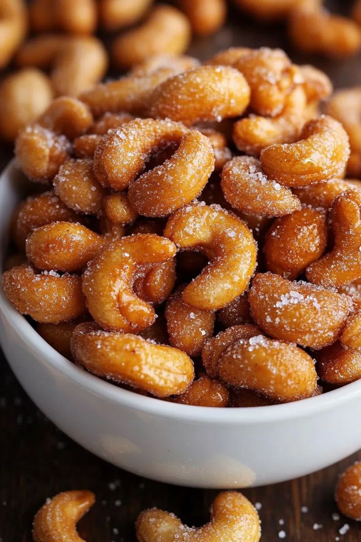 a white bowl filled with sugar coated doughnuts