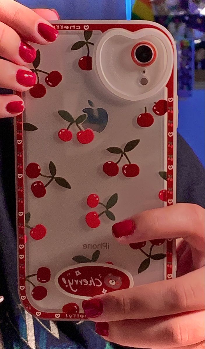 a woman holding up a cell phone case with cherries on the front and sides