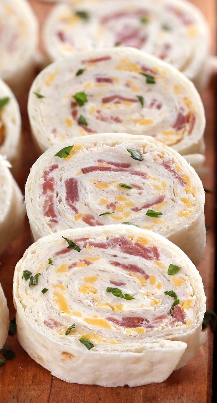 rolls filled with cheese and ham on a wooden cutting board