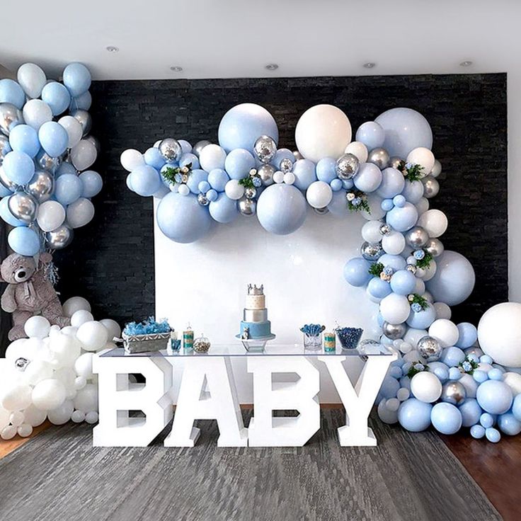 a baby shower is decorated with balloons and streamers in blue, white and silver colors