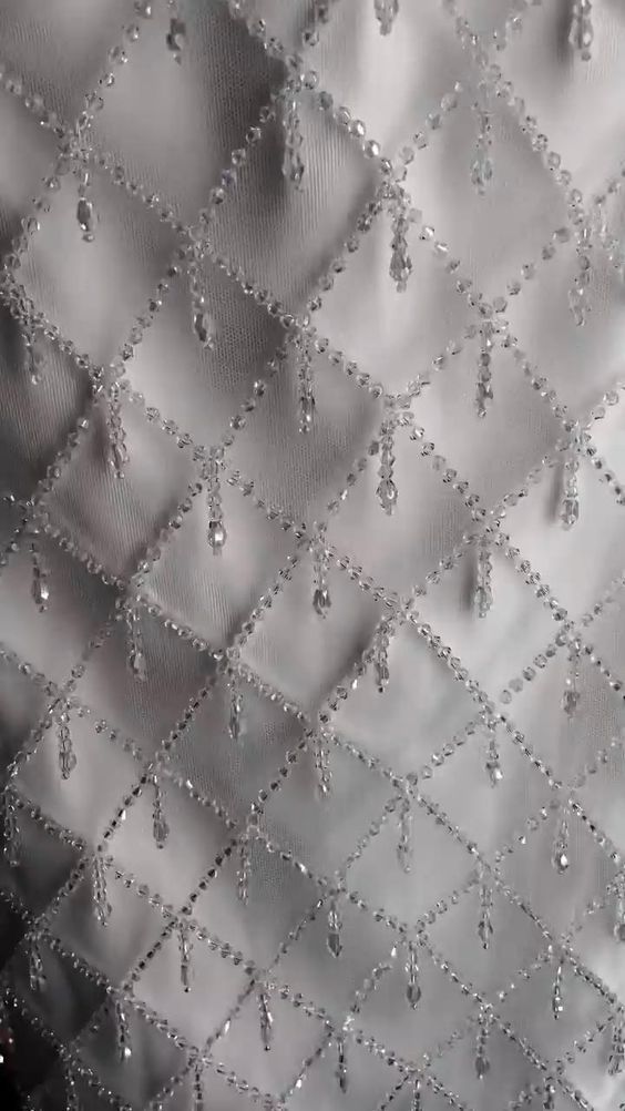 water drops are on the surface of a silver cloth with black and white squares in the background