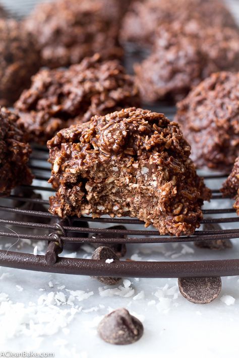 chocolate cookies are cooling on a wire rack with coconut flakes around them and one is half eaten