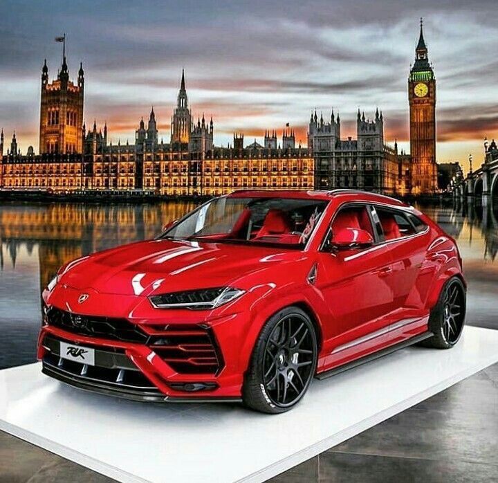 a red sports car is on display in front of the big ben clock tower and houses of parliament