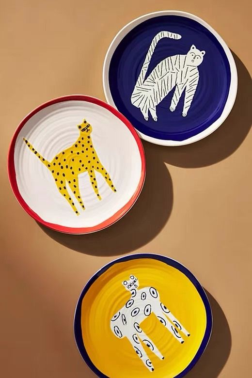 three plates with animal designs on them are arranged in the shape of giraffes