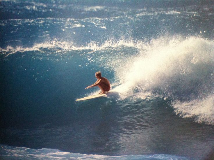 a man riding a wave on top of a surfboard in the middle of the ocean