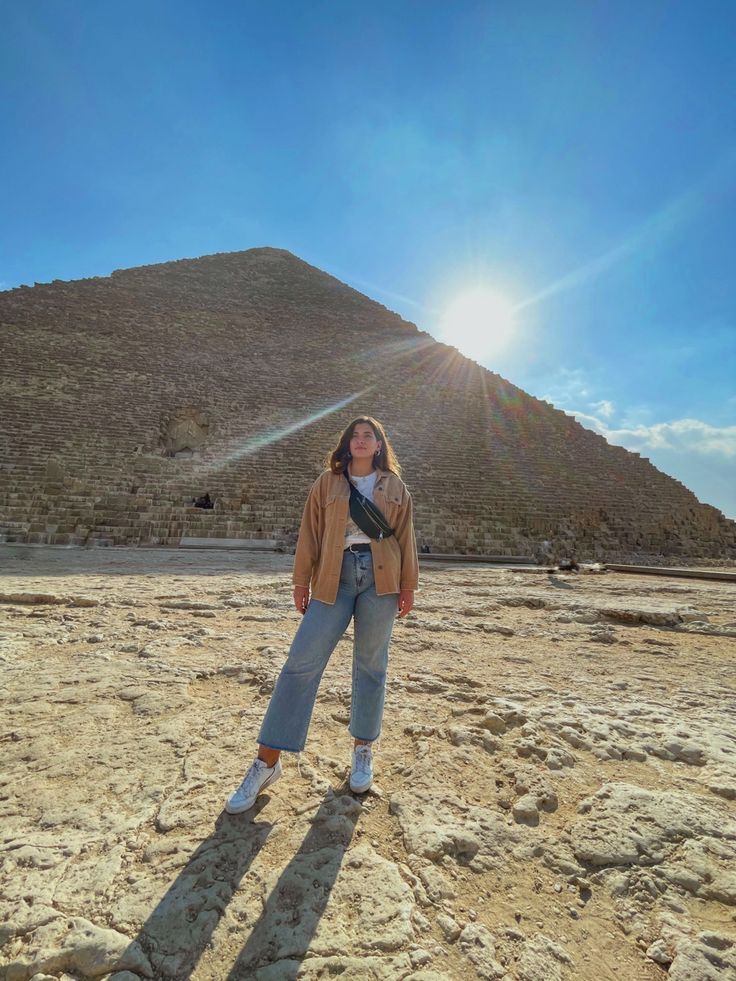 a woman standing in front of the great pyramid