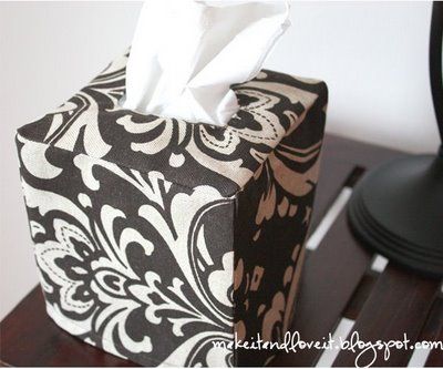 a tissue box sitting on top of a wooden table next to a black and white lamp