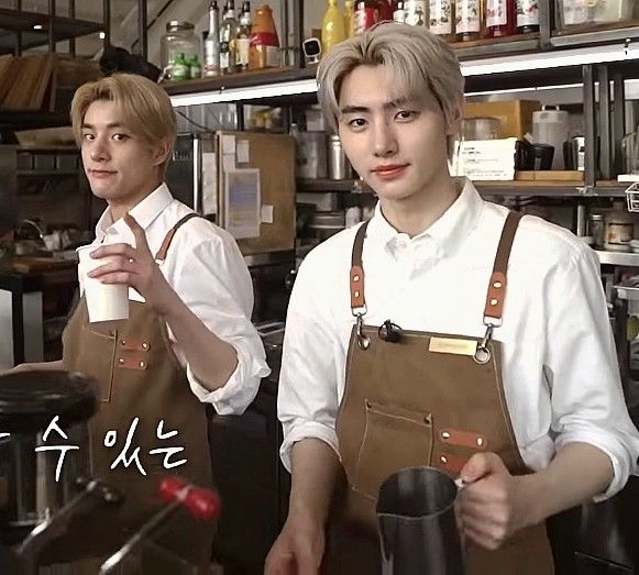 two men in aprons are holding coffee cups