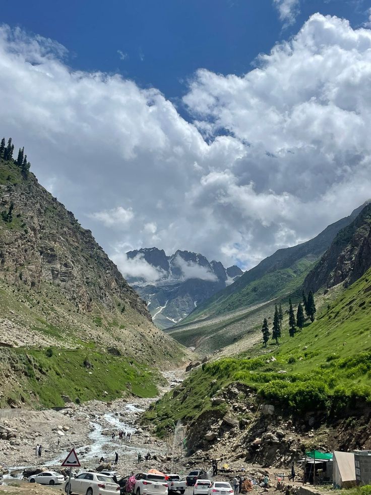 several cars parked on the side of a mountain road