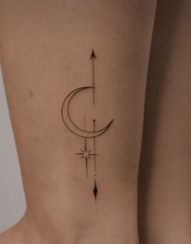 a woman's lower back tattoo with an arrow and crescent