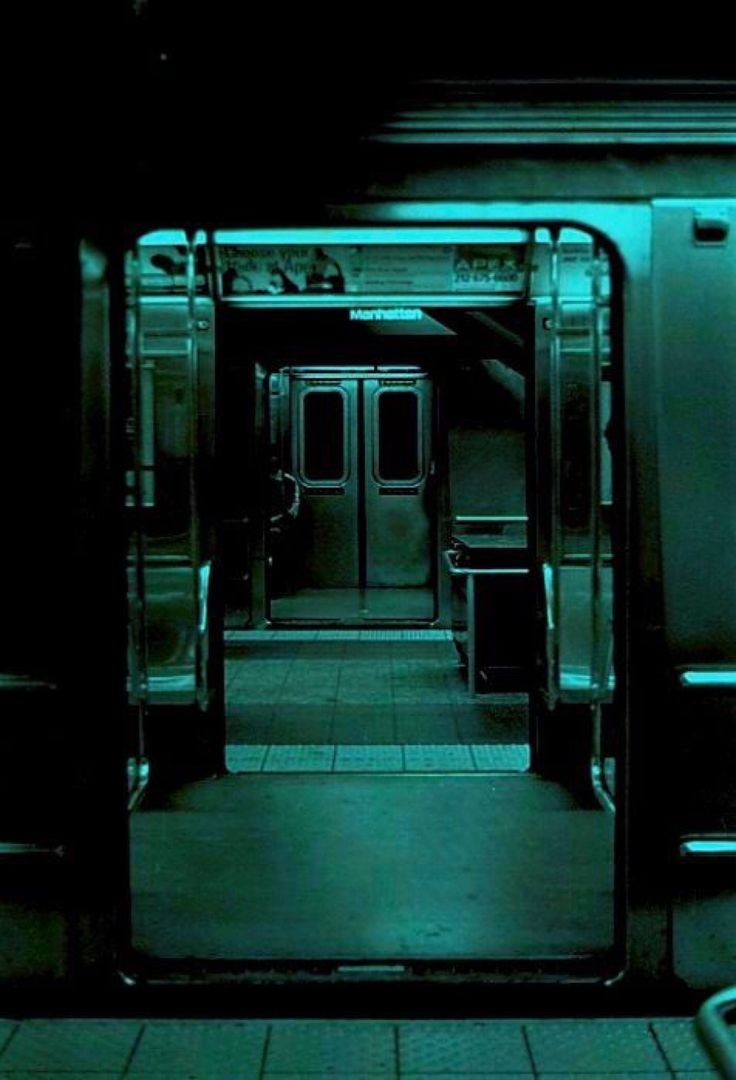 an empty subway car with its doors open in the dark, and no people inside