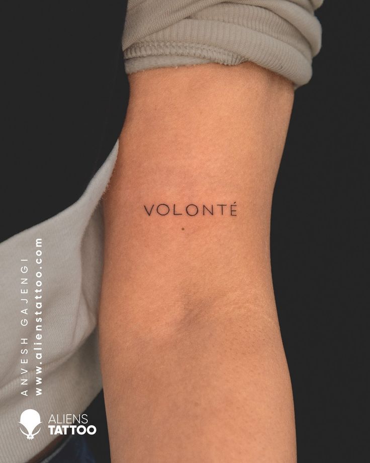 a woman's arm with the word volontte tattooed on her left side