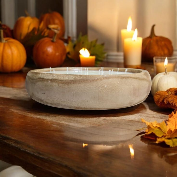 a table with candles, pumpkins and other autumn decorations on it's surface