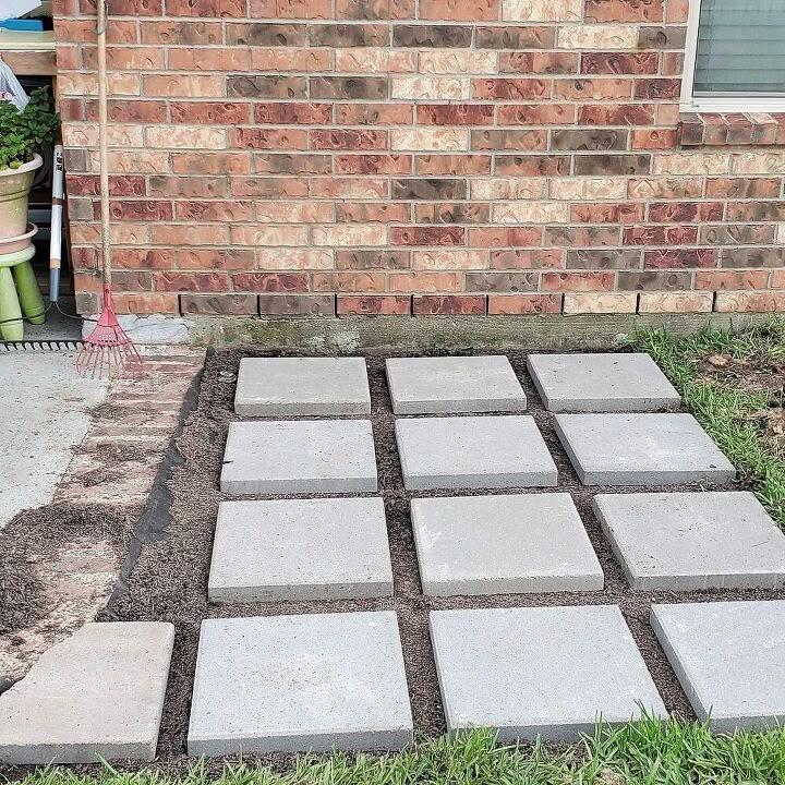 a cement block laying on top of grass next to a brick building