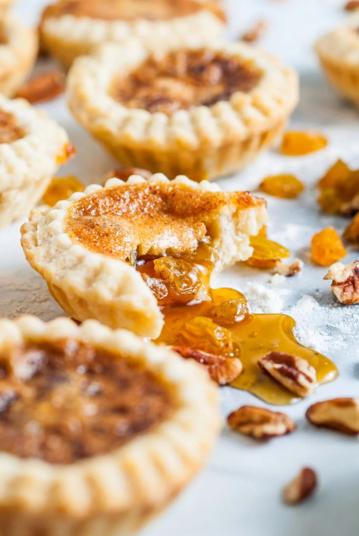 several small pies on a table with nuts scattered around them and one half eaten