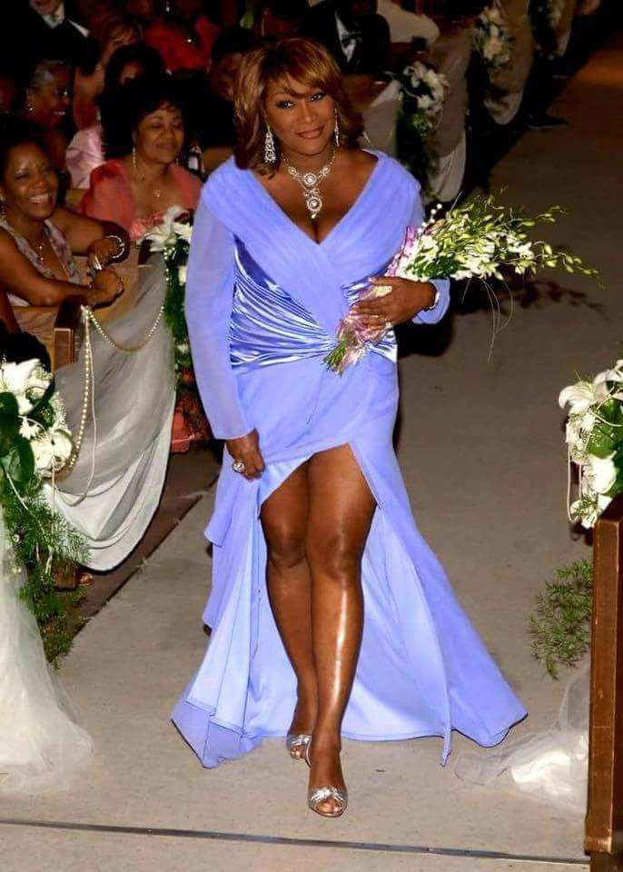 a woman in a blue dress is walking down the street with her legs spread out