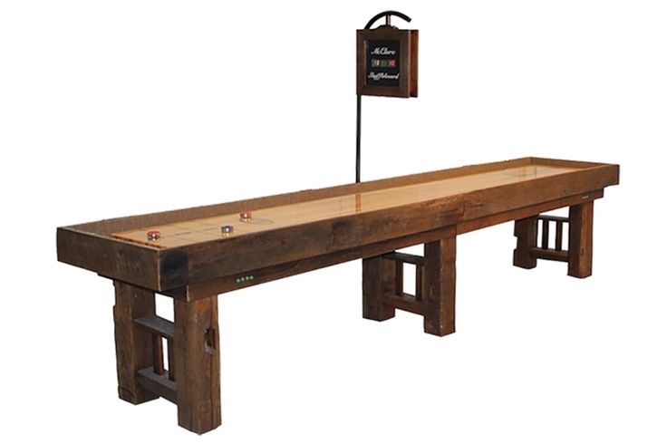 a long wooden table with two benches underneath it and a sign on the back side