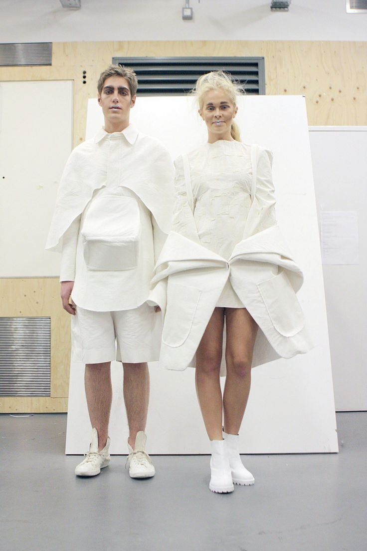 two people standing next to each other in white outfits with large pieces of clothing on them