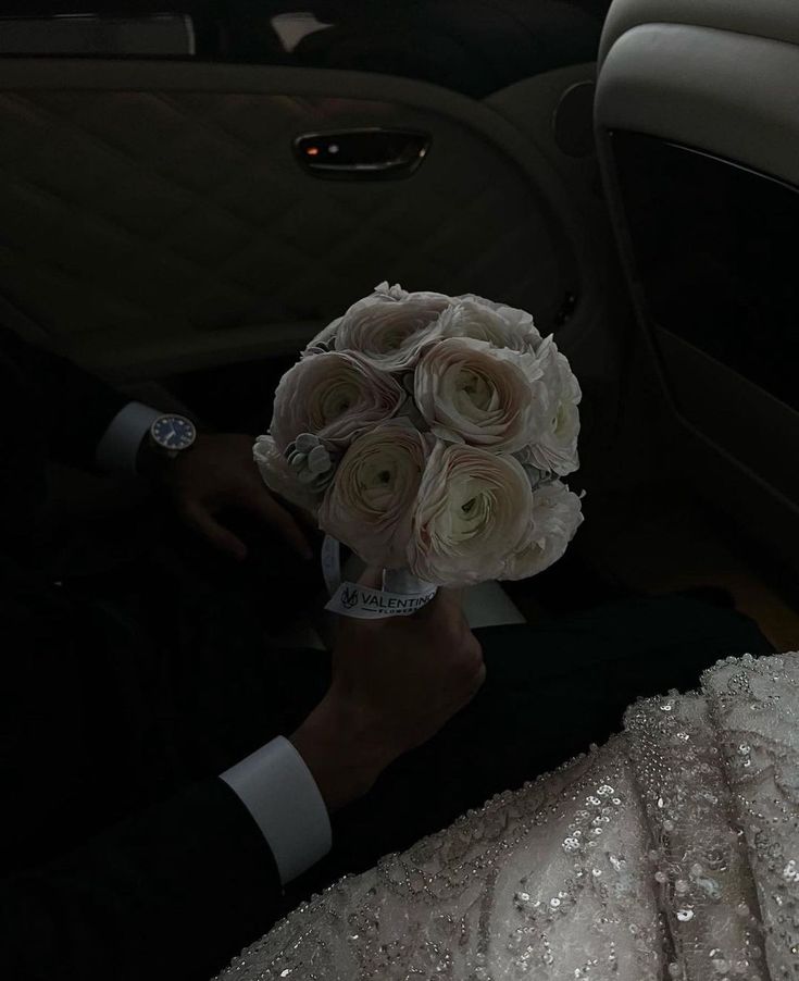 a person in a car holding a bouquet of flowers