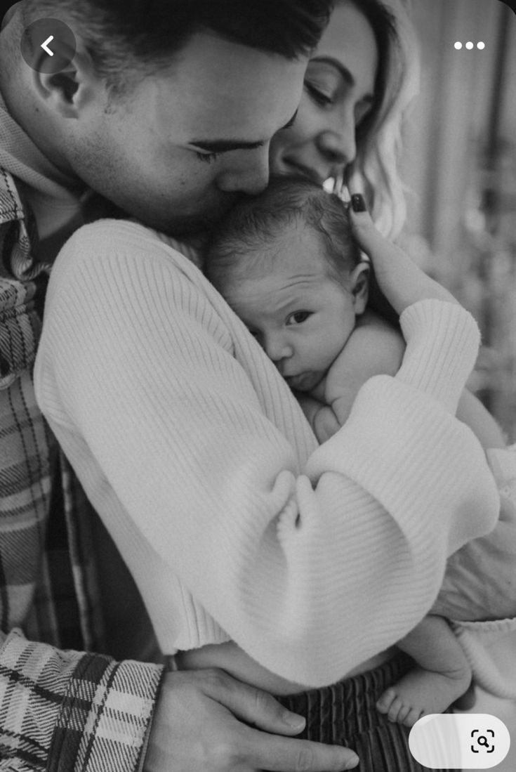 a man and woman holding a baby in their arms