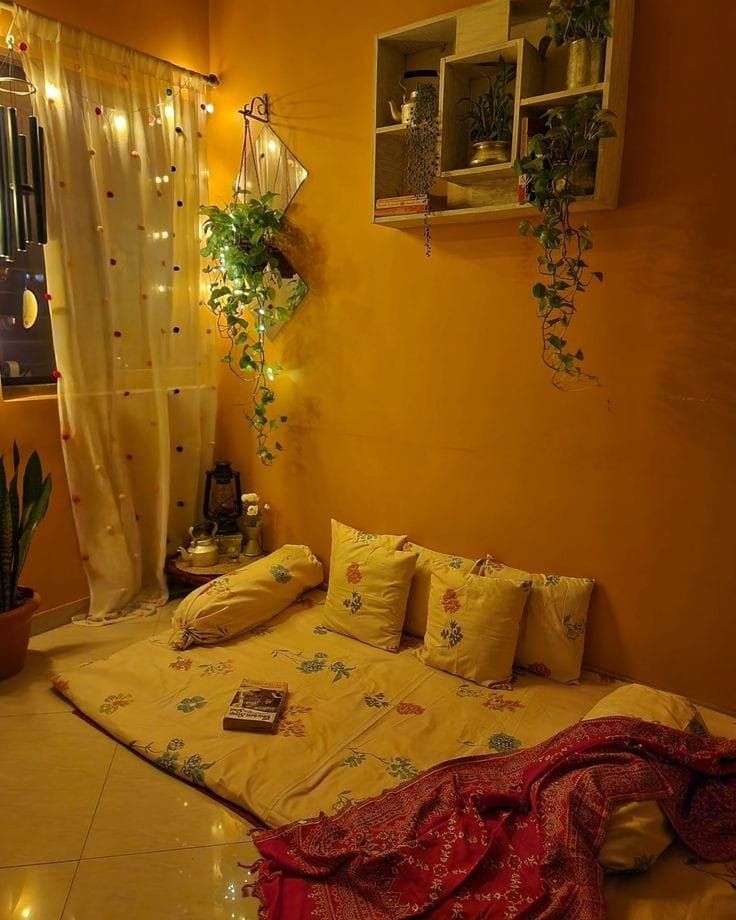 a bed room with a neatly made bed and some plants on the window sill