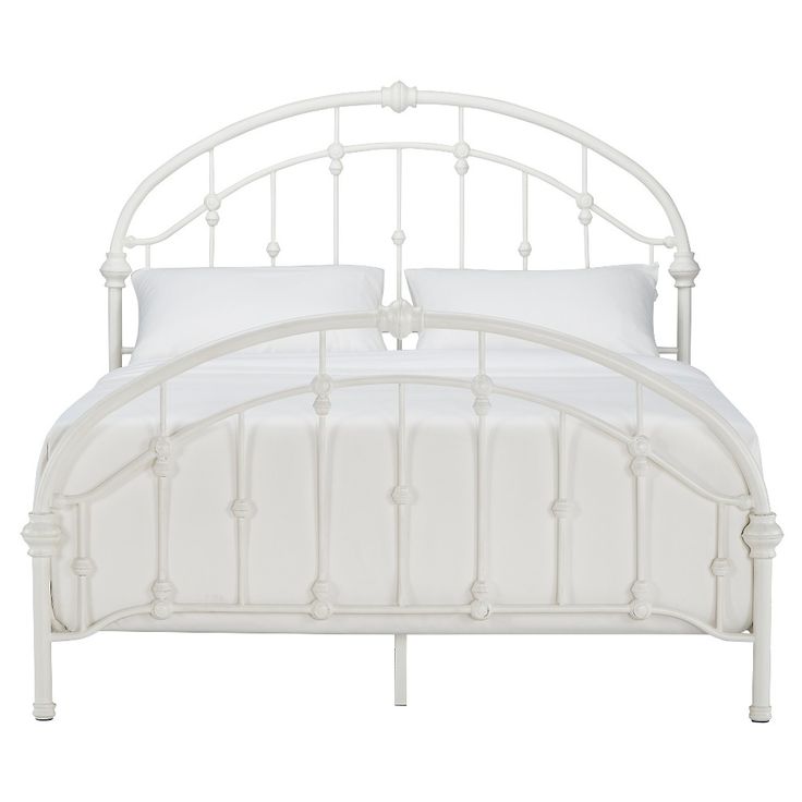 a white metal bed frame with two pillows