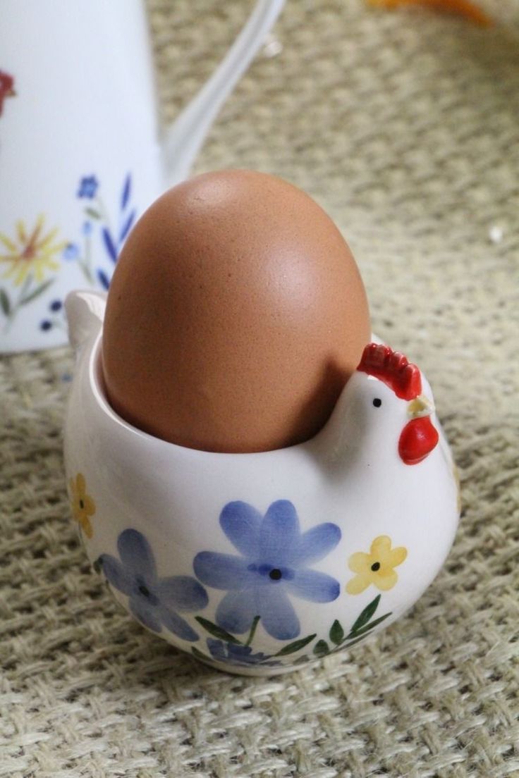 an egg in a ceramic cup with flowers on it