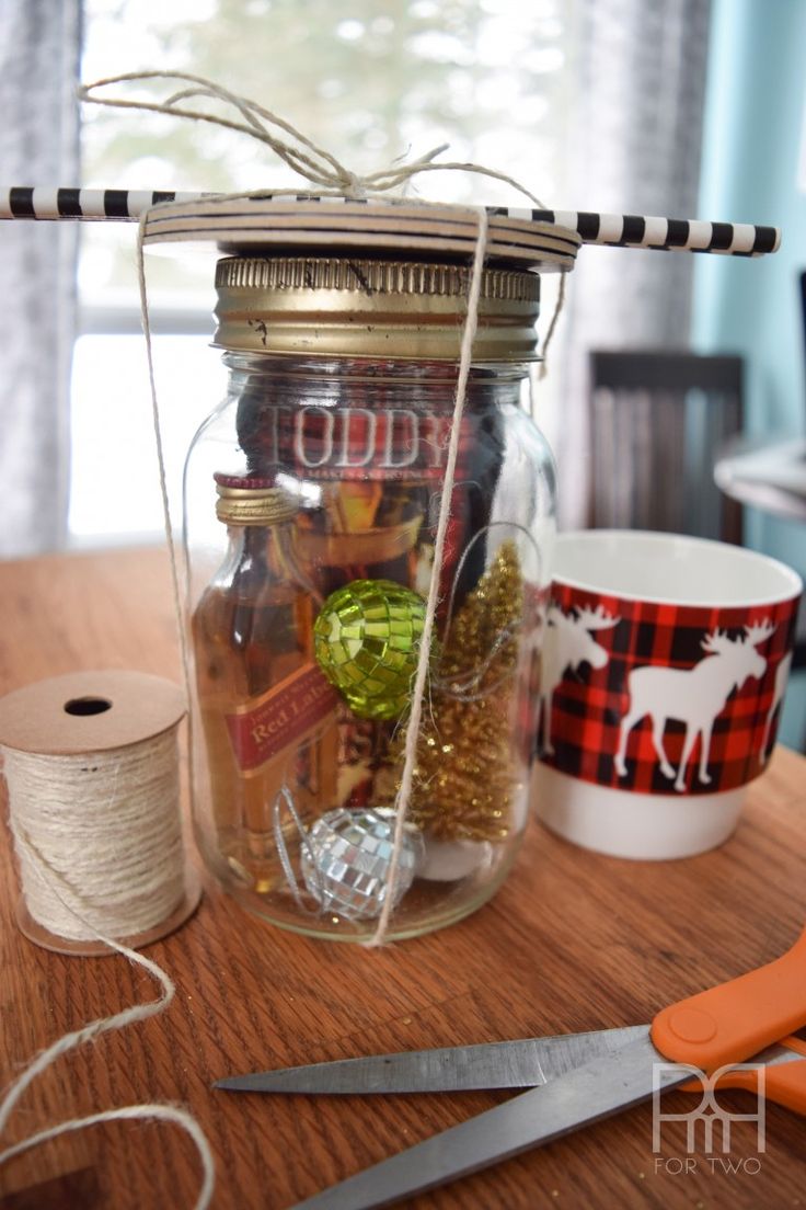 a jar filled with lots of crafting supplies on top of a table next to scissors