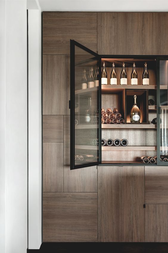 an open cabinet with bottles and glasses in it