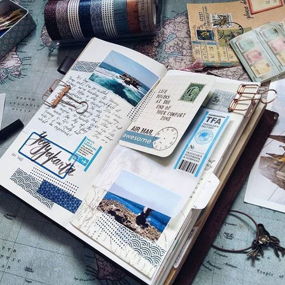 an open book sitting on top of a table covered in papers and other items from around the world