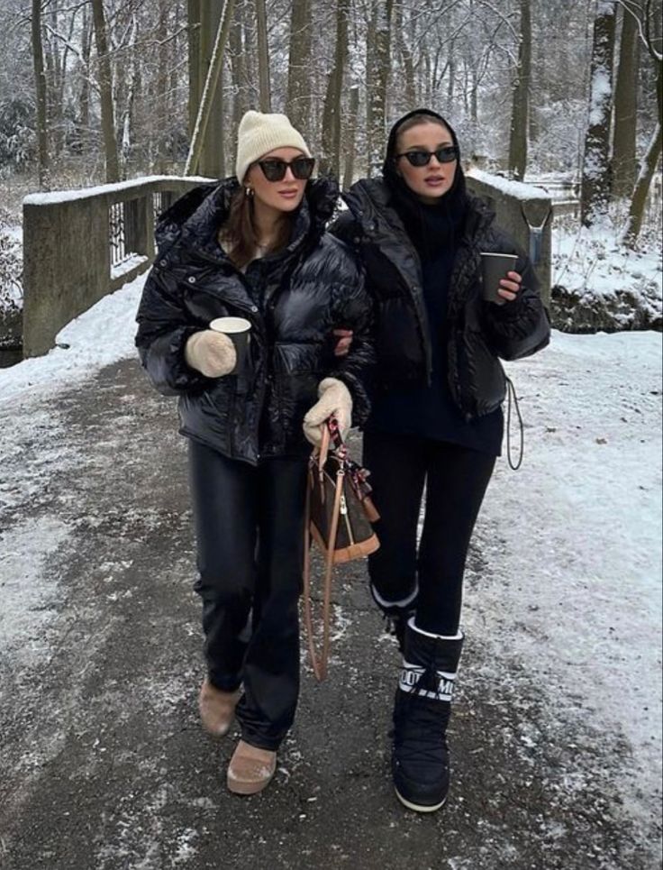 two women walking down a path in the snow