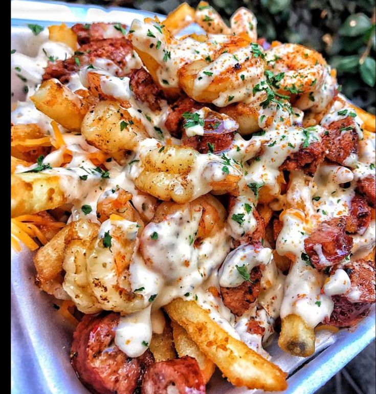 a close up of a plate of food with french fries and sauce on it's side