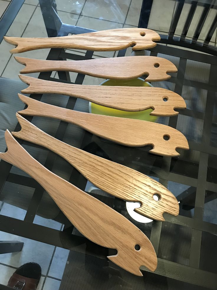 four wooden spoons sitting on top of a glass table