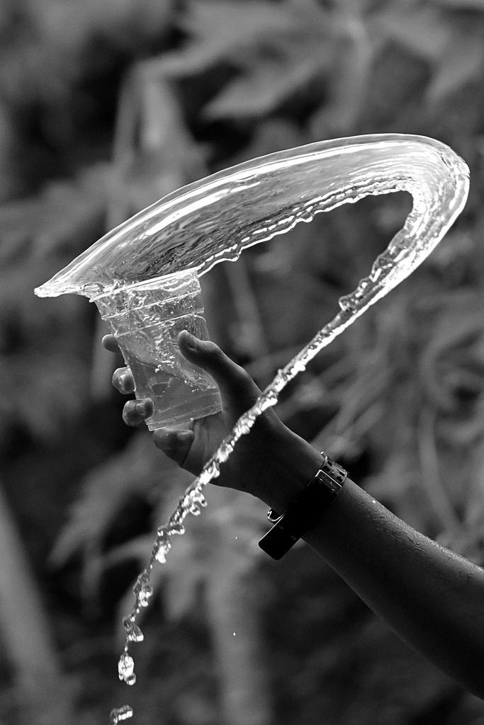 a person holding a water hose in their hand and spraying it on the other side