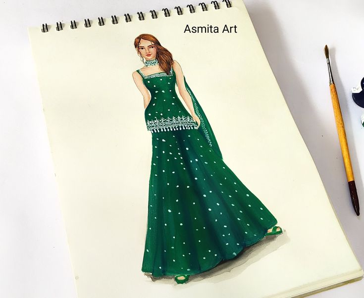 a drawing of a woman in a green dress on a notepad next to a pencil