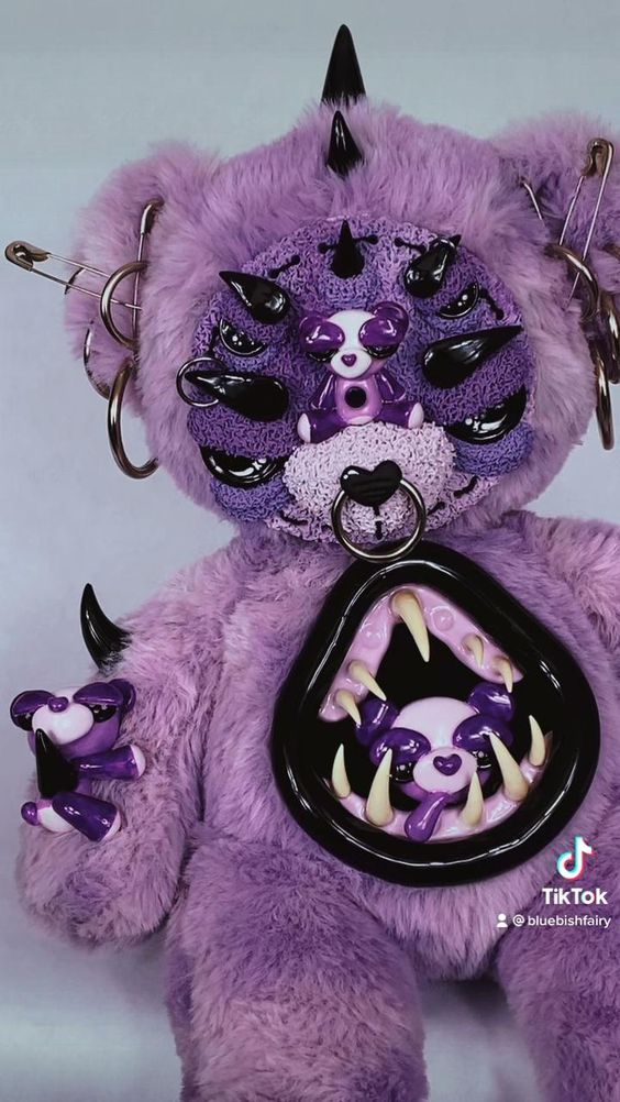 a purple teddy bear with black and white designs on it's face holding a bag