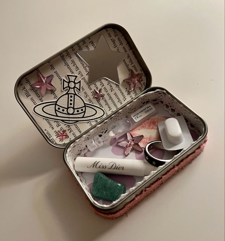 an open tin container with various items in it