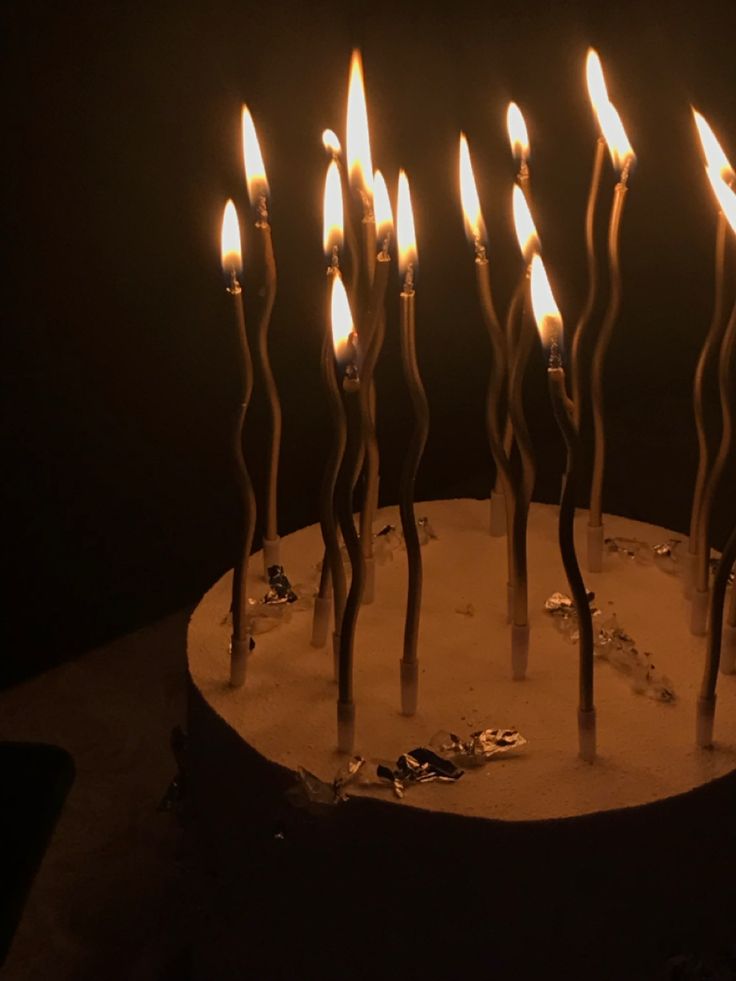 there are many candles that are lit on the cake, and it looks like they're going to blow out