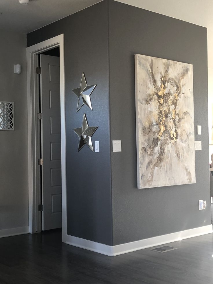 a living room filled with furniture and paintings on the wall