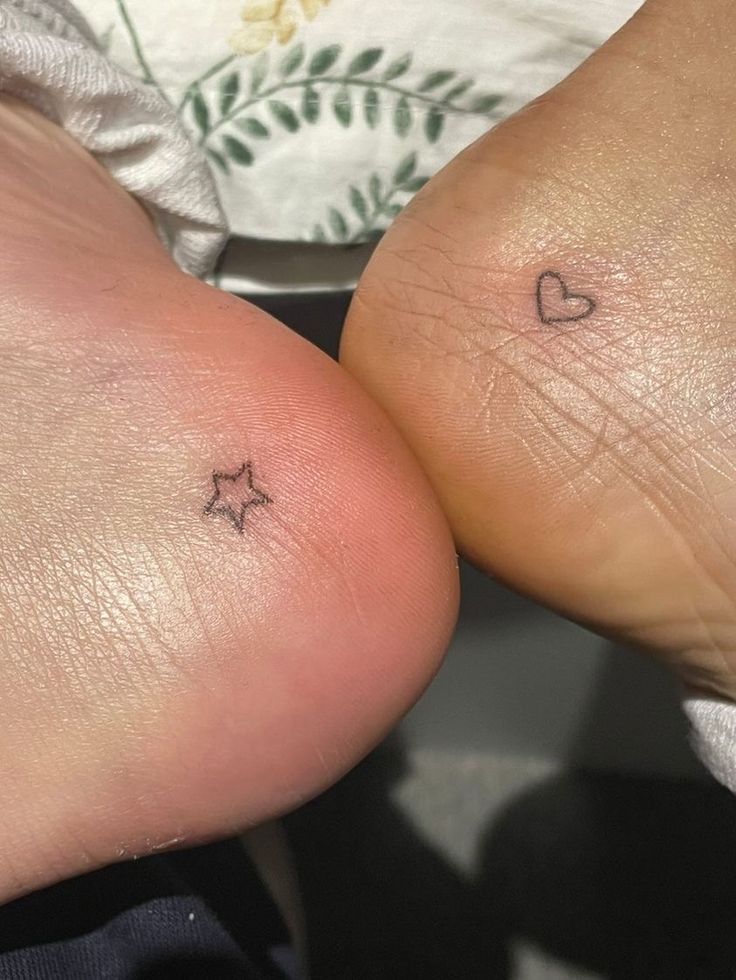 two small tattoos on the legs of someone's feet, both with hearts and stars