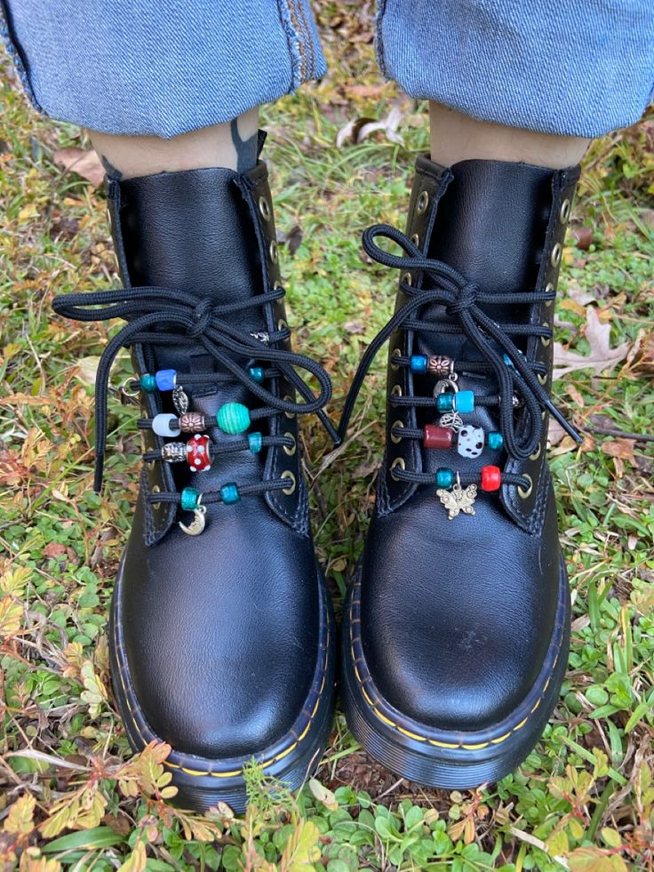 Black doc marten boots with different colored glass beads on the laces Upcycled Doc Martens, Decorating Doc Martens, Doc Martens Beads On Laces, Doc Marten Ribbon Laces, Doc Martens Beads, Beaded Doc Martens, Dr Martens Accessories, Diy Combat Boots, Doc Marten Charms Diy