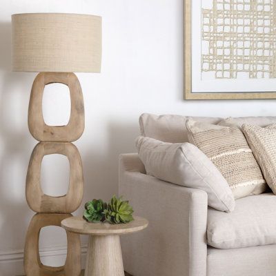 a living room filled with furniture and a lamp on top of a wooden table next to a white couch