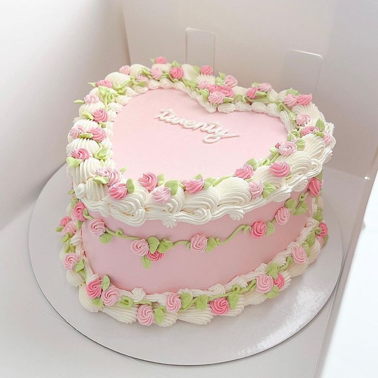 a heart shaped cake with pink and white frosting